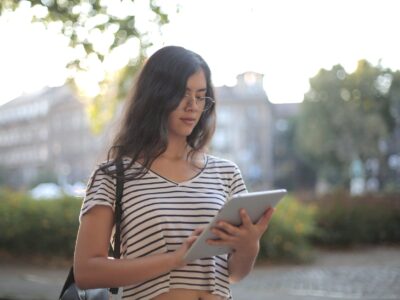 calm pensive female freelancer using digital tablet on street