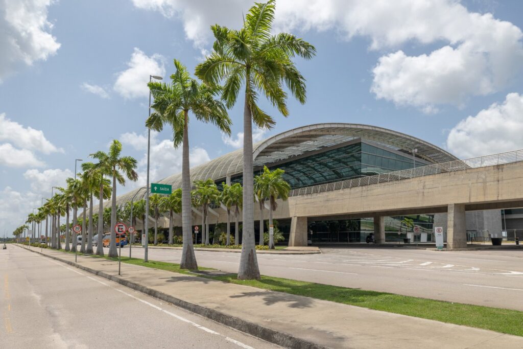 Fachada do Aeroporto Internacional de Natal, em São Gonçalo do Amarante, com palmeiras imperiais na via de acesso