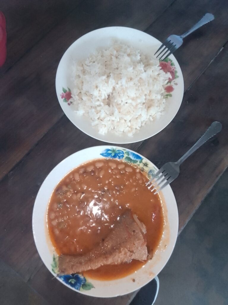 Prato simples com arroz, feijão e peixe grelhado servido em pratos de louça