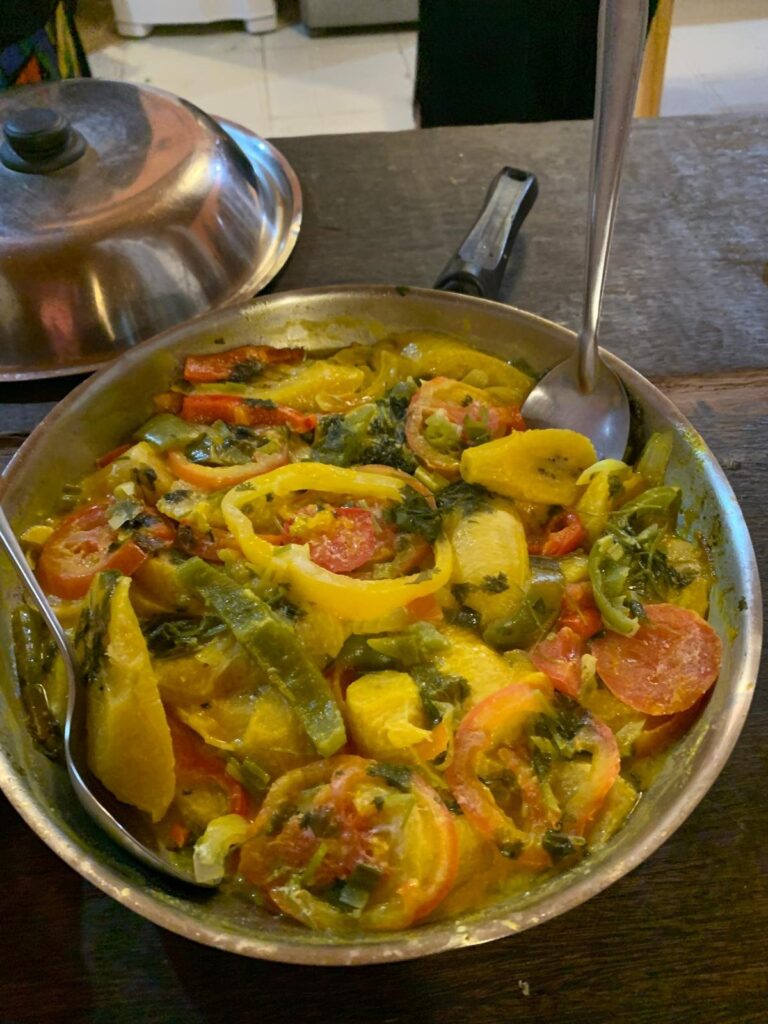 Panela de moqueca de peixe com pimentões, tomate e coentro