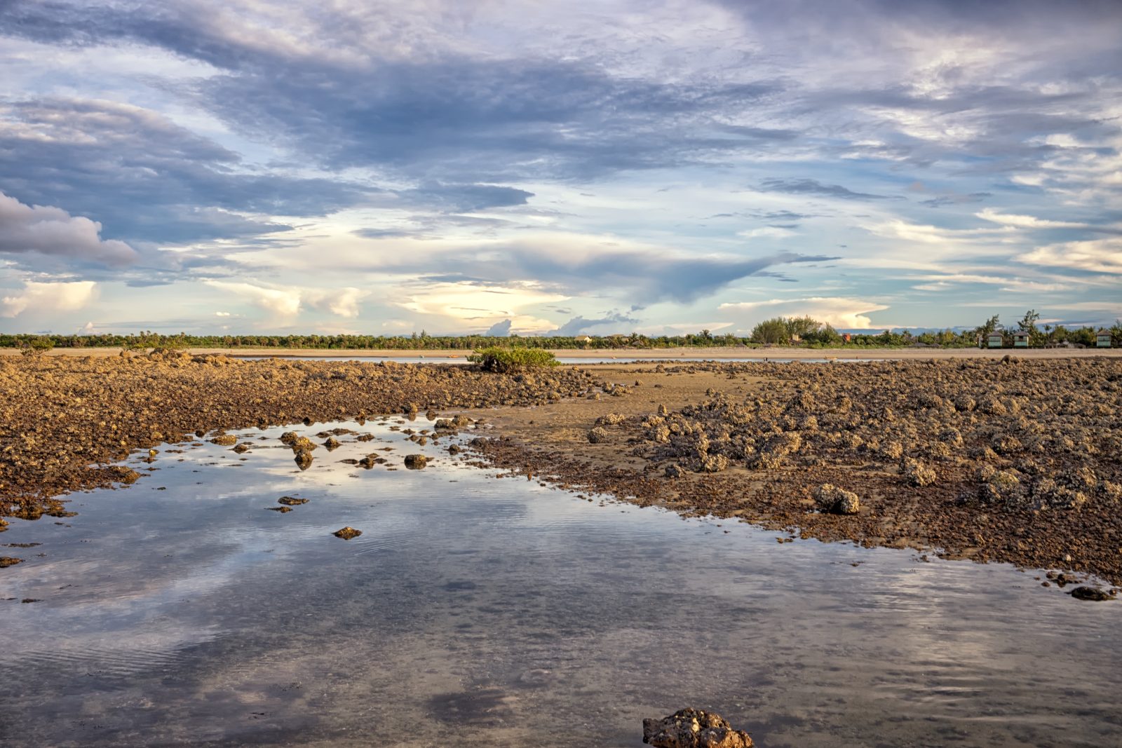 Beira-mar de Barra Grande na maré baixa com pedras e poças de água