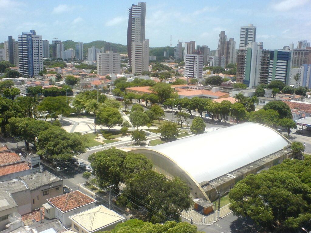 Vista aérea da Praça Cívica, em Petrópolis, cercada de árvores e prédios residenciais