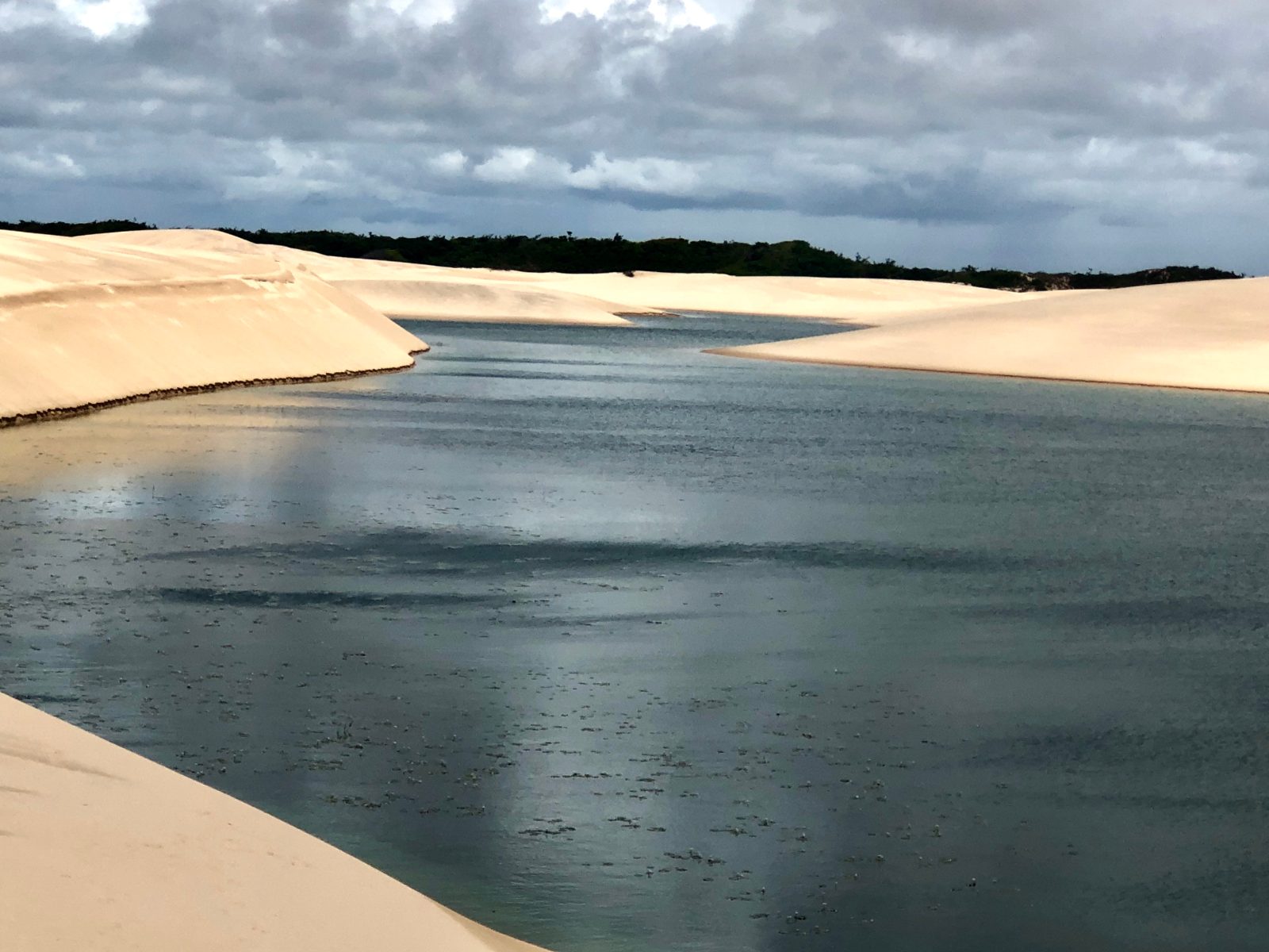 Dunas e lagoa no Canto do Atins sob céu nublado, nos Lençóis Maranhenses