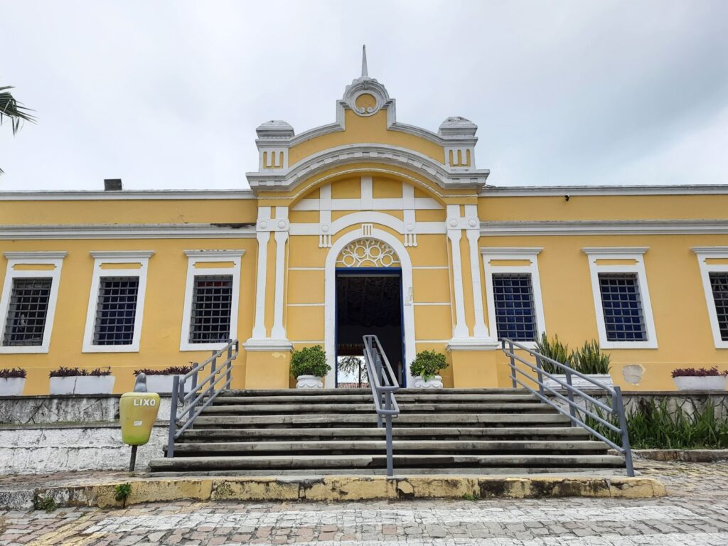 Fachada amarela do Centro de Turismo de Natal, prédio histórico com escadaria e janelas brancas