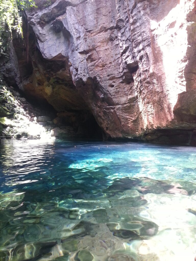 Poço de água azul-turquesa ao pé de um paredão de pedra, no Encanto Azul, em Riachão