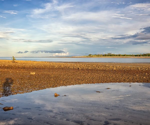 Praia de Barra Grande na maré baixa com areia molhada e céu aberto